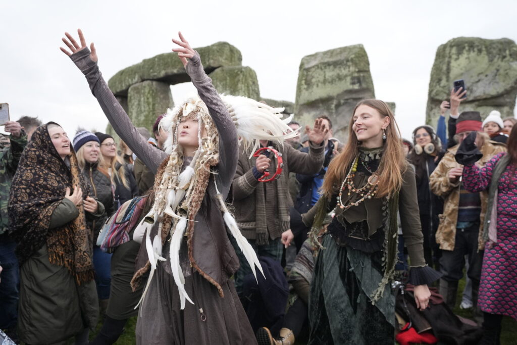 Gente participa en las celebraciones del solsticio a amanecer en el monumento prehistórico de Stonehenge en la llanura de Salisbury, en Wiltshire, Inglaterra, el domingo 21 de diciembre de 2025. (Andrew Matthew/PA via AP)